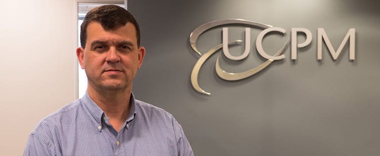 Bart Jarman standing in front of UCPM sign in reception area