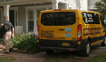 Stanley Steemer van parked in front of a house